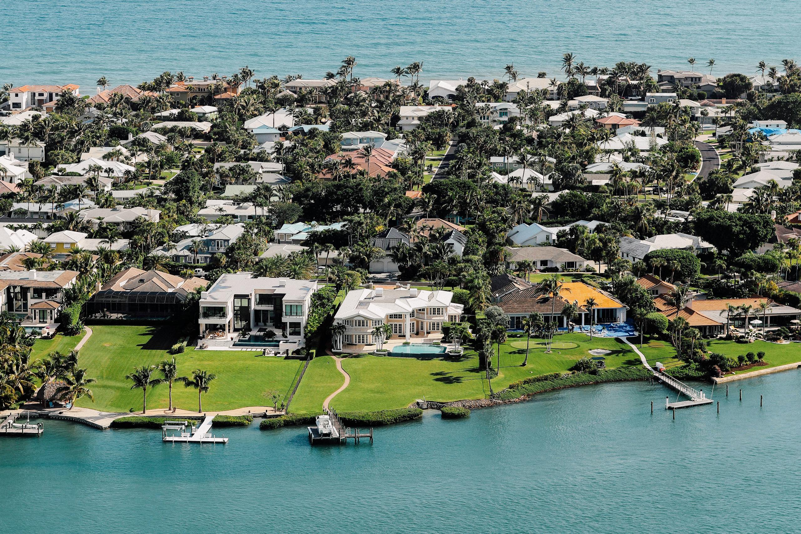 Aerial view of luxurious waterfront mansions on a tropical island.